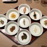 一碗水 - 七彩盆（手羽先の唐揚げアミエビ風味・たけのこ川のり風味・あんこうの煮凝り・ゆり根の寄せ物・中国生麩、椎茸、棒ゆばの精進煮・くらげの唐辛子和え・黒毛和牛すね肉の香料煮・白菜のマスタード漬け・発酵緑豆おから炒め）