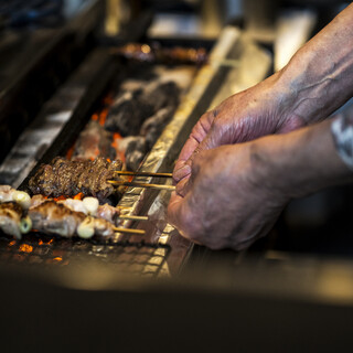Enjoy the finest Yakitori (grilled chicken skewers) experience illuminated by charcoal flames.