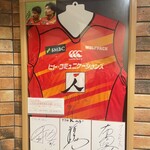 グリルK - 店内にはラグビージャージ（懐かしいサンウルブス）と選手のサイン（左から松田、稲垣、布巻の各選手）