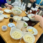 四ツ木製麺所 - トミさんとお話しする仲間とうどん取り分けてくれる仲間