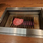 焼肉うしごろ - 2枚目のリブロースを、網の鉄板の上で焼いている様子です。