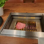 焼肉うしごろ - 網の鉄板の上で焼いているリブロースです。
