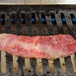 TOKYO焼肉ごぉ - すき焼きカルビ(月見ダレ付)のカルビを焼いているところ