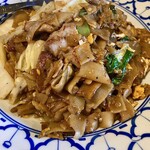 タイの食卓 パクチータイ - 平打ちの太麺と一緒に、たっぷりの豚バラ肉、白菜、キャベツ、小松菜、玉子などが炒められています。