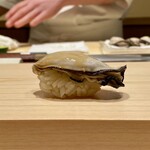 鮨 めい乃 - かき　長崎県小長井より
      握りのフォルムが美しい！
      この牡蠣めちゃくちゃ美味しいです♪
      聞けば、さっとボイルして軽く酢締にしているそうです。
      ぷっくりとして強い旨み、それでいて後味スッキリ、旨すぎです！