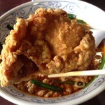 Kisshou - 吉勝 大津店のほうれん草叉焼麺の鶏の唐揚げ、デカい！背景はラーメン鉢。（14.01）