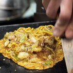 お好み焼き Sakura - 「卵ぶっかけ」とは溶いた卵に作ったブタ焼きそばを豪快に入れ
            それを鉄板の上で紡錘状に成形していく