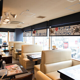 A clean interior with a total of 60 seats overlooking Okubo Street from the large glass windows.
