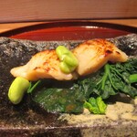 京味 もと井 - 焼き物 ： 鰆の西京焼き。串を打ち、西京焼きにした鰆の下に ちぢみ法蓮草が敷かれ、上にはそら豆の艶煮が添えられています。 ほうれん草をいただくとフッと山葵が香ります。
