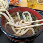 武蔵野うどん 山崎 - こんな風に肉汁の御椀に入れるわけよね。結構長いし重たいから掬(すく)って御椀に入れようとしても難しいよ。ずるずると引きずって入れんの。補足：麺を2本だけお箸で摘んでずるずると引きずって入れれば簡単よ