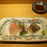 好日 - お造り ： 三河湾産 石鯛 昆布〆にして寝かしてあります。和歌山産 かます 焼き霜。 すだちが添えられ、お好みに合わせて お塩か山葵でいただきます。 浜防風の茎を縫い針で割いてクルリと錨状にしてあります。お洒落ですネ！