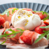 プーリア産ブッラータチーズを生ハム、季節のフレッシュフルーツと