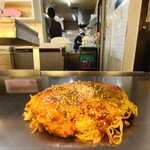 Okonomiyaki Kaede - ファミレス風の内装だけどテーブルが鉄板テーブル
                        お席は鉄板カウンター6席、鉄板テーブル4席×5卓、小上がりに座鉄板テーブル6席×8卓の合計74席
                        裏方さんはずっと千切りキャベツを切っていました