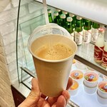 ITAGAKI DESSERT KITCHEN - お店ショーケースを背にした「コールドプレスジュース〈不知火〉」