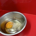 ラーメン二郎 - 汁無し注文時に来る生卵に胡椒をはふりかけたもの