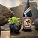 遊食豚彩 いちにいさん - 大きなテーブル席の真ん中に黒豚と焼酎