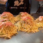 Ganso Henkutsuya - 生地の上にキャベツどっさり、もやし、豚肉、もやし、後はトッピングを入れて作っています！