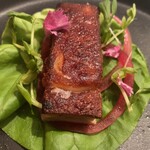 スリオラ - 乳飲み仔豚のプランチャに玉葱のピクルスをサラダ菜でクルッと巻いて頂きます