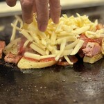 お好み焼屋みっちゃん - 『じゃがベーコンチーズ』 ※ となりの方の注文(人´∩｀)
      こんがり焼けたじゃがいもとベーコンのバター炒めを
      Wケチャップ+ チーズで蒸し焼きに