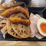 石焼つけ麺 繋 - 「カレーつけ麺」と一緒に添えられる具材。チャーシュー、玉子のほか、素揚げされた野菜たち