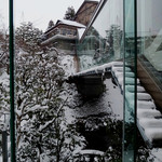 辻家庭園 - 本館と新館を繋ぐ渡り廊下はブリッジ状に浮いており，その下に，左側の大瀧から流れる水が注ぐ池がある。ブリッジは，庭方向天地ガラスという眺望重視の設計。