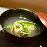 Ginza Ugai - ❸椀 ～蓋を開けるとふわっと春の香り。富山産と蛍烏賊と障泥烏賊の真薯、障泥烏賊の粘りだけでつなぎ濃厚な蛍烏賊の旨味が出汁に溶け込み、さらに山菜のコゴミとウルイ、山椒の葉の香りが春らしいお椀に。