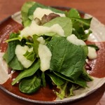 焼鳥 せきね - 人気のドレッシング(たまねぎドレ)で食べるほうれん草とルッコラのサラダ