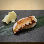 Sushi Mashio - 江戸前の真蛸
                      生きた蛸を捌いて桜煮にしています
                      継ぎ足されたツメで召し上がってください