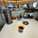 てんぷら 一代 - ポットの中身は黒烏龍茶。肉惣菜、天つゆ、塩、カレー塩が並ぶ。明太子は店員が都度皿に盛り付けてくれる。