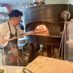 パラダイス ピザ - 薪窯にピザを入れる