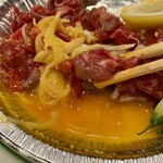 焼肉 鶯谷園 - 焼きユッケに黄身をからめて