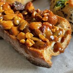 あおぞら - キャラメルナッツカスクート¥350内　豪華美味い。バゲットはクープ(切り込み)の入った面が使われていた。硬くて鋭利なバゲットと載せただけのナッツは噛みちぎって食べるのには不向きだ。