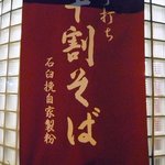 真紅の生地に白抜きで、ガラスの所にはこんな風に書いてます。手打ち十割そば石白挽自家製粉