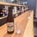 らぁめん せんり - 瓶ビールとカウンター風景。このストレートなカウンターは厨房の反対側にもある。これ、もしかして1枚板？…だとしたらすごいと思う