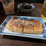 カド - 山椒昆布（奥）、油揚げを焼いてネギを詰めたもの（手前）