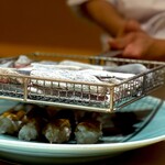 くるますし - これで出来上がりかと思ったら違うんですよ。 1度炙り終わったら、ここにイセエビのミソをたっぷりかけて、再度、 炭で炙るんです。 弟子くんが炙って大将が横からまたまたチェック。 ミソが、プクプクなってきたら出来上がり。 二人がかりでほんと大変。 いい香りを前に、僕らはよだれ垂らしてワンコになります。