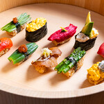 Onari Yokochou Dashi To Supaisu To Kidoki Vi-Gan - この野菜寿司は、鎌倉野菜や旬野菜をたっぷりと使用し、野菜の鮮やかな色合いと自然な甘さを堪能できます。
      各野菜の魅力を最大限に引き立てるために丁寧に仕込んだ具材が、赤酢を使った
      シャリと見事に調和し、口の中でまったく新しい味の体験が広がります。
      栄養満点で美味しさも抜群、満足感が高い、ユニークな料理をお楽しみください。