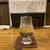 酒と飯 古今 - ドリンク写真:酒のグラスいっぱいは均一。銘柄、グレードによりいっぱいの量が変わる。これは鶴の友純米で120㍉㍑