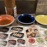 秋吉 - 左からソース　青い皿がタレ　黄色皿がカラシで四角い串はカラシをつけて食べます