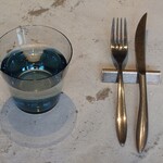 あずきとこおり - 心地良い石造りのテーブル。すっきりとしたフォルムのカトラリー＆ナイフレスト、淡い色をした繊細な作りのウォーターグラス。無駄な部分が一切無い。