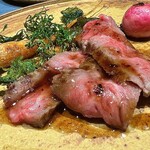 Il Giorno - 広島県産 神石牛いちぼの炭火焼きタリアータ、葉人参 こごみ ラディッシュとスーゴ・ディ・カルネと自然派バルサミコソース。
      