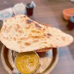 エベレストフード - 待つこと数分、目の前に現れたのは、大きなチキンの塊がゴロゴロと入ったカレー。 その横には厚みのあるふわふわのナンが添えられている。 ナンとカレーの組み合わせは、まさに天聖のハーモニー。 一口食べれば、その味わいに心が奪われる。