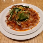 スーツァン・レストラン陳 渋谷店 - 雲白肉です。沖縄県産のきびまる豚三枚肉薄切りの美しい見た目と胡瓜の薄切り、オレンジ色の綺麗な旨辛たれが見事に調和した一品です。