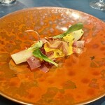 ブラッスリー リーヌ - 黄身のソースで食べるホワイトアスパラ。カリカリにした生ハムがトッピングされてる。ちょっぴりスモーキーなのも風味のアクセントになって良し。