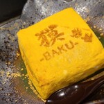 BAKU - ③焼き印付き出汁巻き玉子
                        出汁が効いて良い感じ、大阪なら出汁巻き玉子定食で通じるレベルです