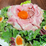 Special Caesar salad with raw bacon and smoked egg