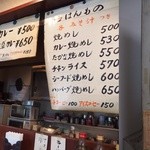 ヒルス＆薔薇屋 - 右：店頭掲示のカレーメニュー。左：店内カウンターに掲示されたメニュー。手元にはメニューはありません