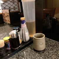 ごちそう家 ぽん太 - カウンター席卓上風景　冷ほうじ茶は2杯目からセルフサービスです