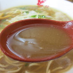 中華そば どん - 朱色のレンゲですくったスープ。