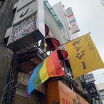 Ganji - お店の黄色いフラッグと2階の窓　その向こうには看板も見えます